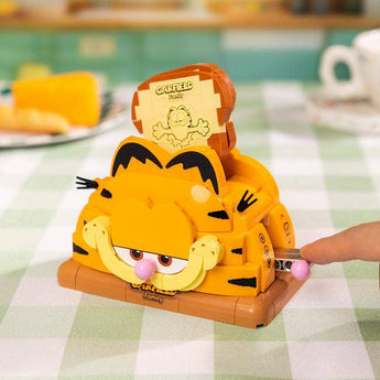 Pantasy x Garfield toaster building set with toast raised as a hand turns the side crank