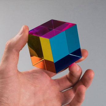 Hand holding the Original 50 mm CMY Cube with overlapping cyan, magenta, and yellow faces
