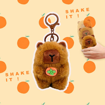 Brown capybara plush keychain charm with orange fruit accent and shake-it demonstration
