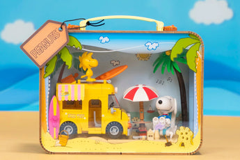 Pantasy Snoopy’s Suitcase building set showing a yellow mini bus, Snoopy, Woodstock, umbrella, and surfboard beach scene