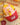 LuLu the Piggy fries figure holding a ketchup-covered fry in a red carton