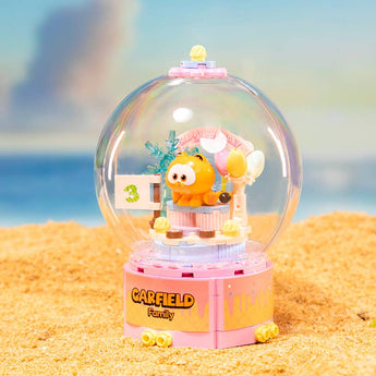 Pantasy Garfield birthday cake building set under a clear dome in a beach-themed display